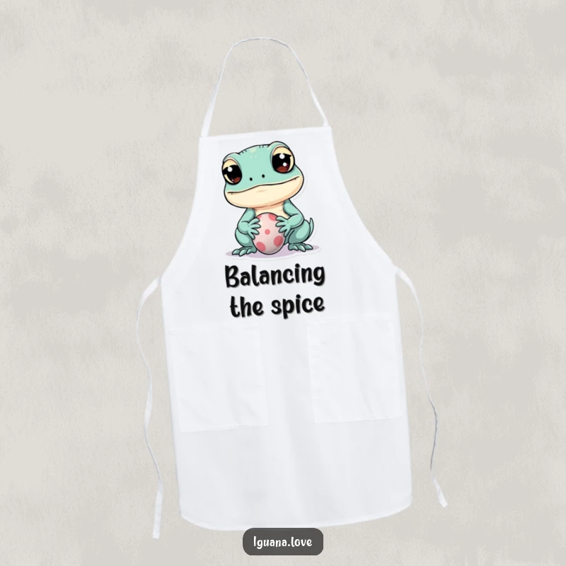 Funny apron showcasing a kawaii iguana with wide eyes playfully balancing a tiny ball on its snout, ideal for kitchen fun.