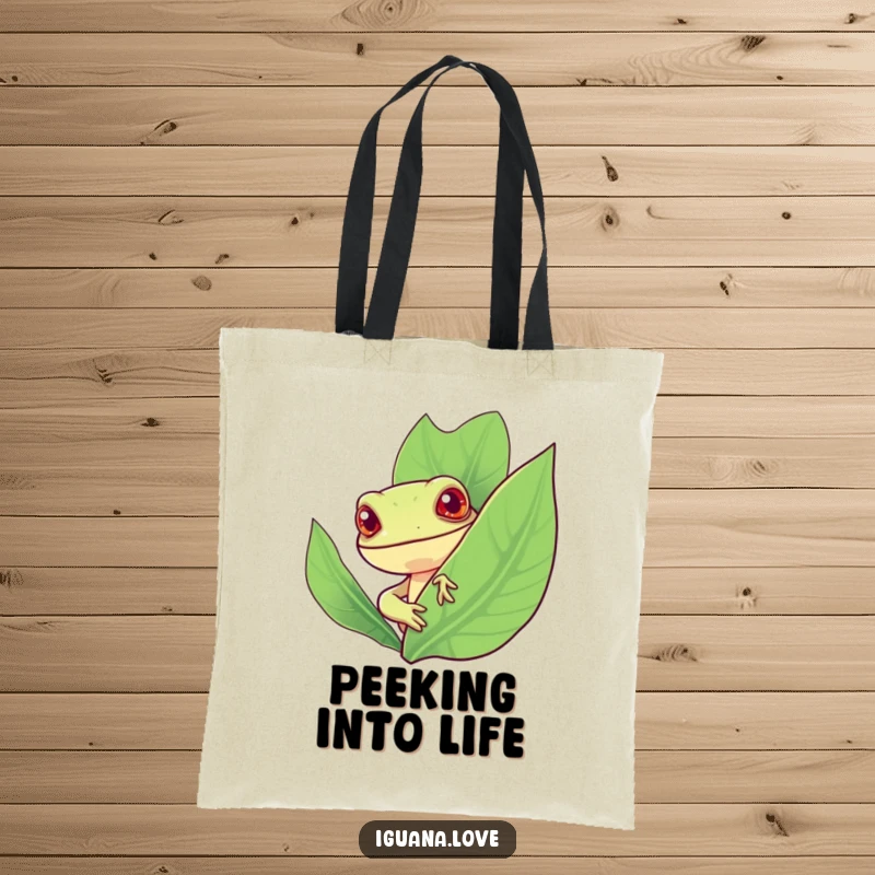 Funny tote bag depicting a stylized iguana with a cheerful expression peeking curiously from behind a large, vibrant leaf.